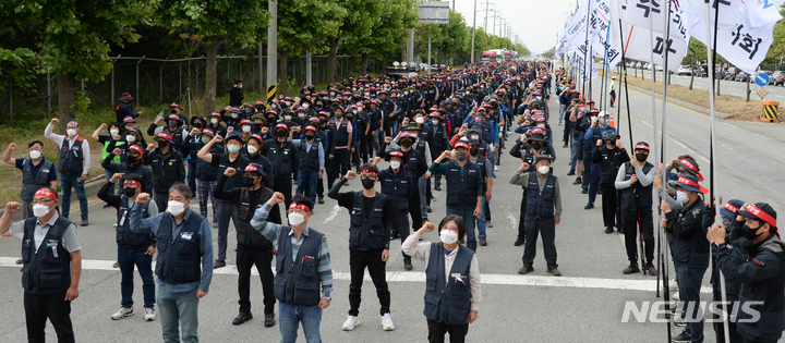 [군산=뉴시스] 김얼 기자 = 민주노총 공공운수노조 화물연대본부 관계자들이 7일 전북 군산시 군산항 5부두 앞에서 화물연대 총파업 출정식을 열고 구호를 외치고 있다. 2022.06.07. pmkeul@newsis.com