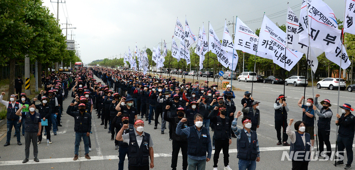 [군산=뉴시스] 김얼 기자 = 민주노총 공공운수노조 화물연대본부 관계자들이 7일 전북 군산시 군산항 5부두 앞에서 화물연대 총파업 출정식을 열고 구호를 외치고 있다. 2022.06.07. pmkeul@newsis.com