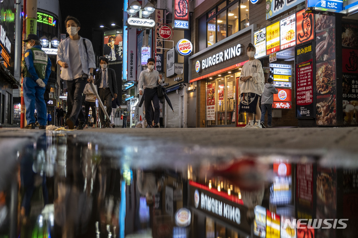 [도쿄=AP/뉴시스]지난해 10월1일 일본 도쿄의 시부야에서 시민들이 술집과 식당의 전광판이 즐비한 거리를 걸어가고 있다. 2022.06.08.