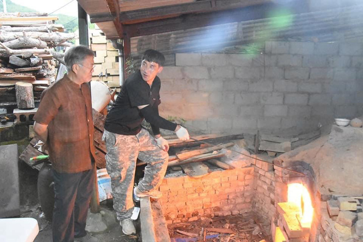 [서울=뉴시스] 문재인 전 대통령이 지난 7일 경남 양산 평산마을 사저 옆 도예 작업장에서 주민과 함께 하고 있는 사진을 SNS를 통해 공개했다. (사진 = 문 전 대통령 SNS 캡처) 2022.06.08. photo@newsis.com *재판매 및 DB 금지