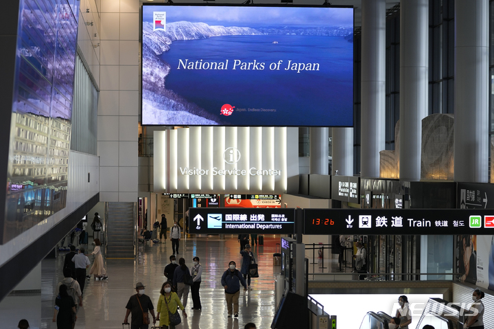 [나리타=AP/뉴시스]지난 6월10일 일본 도쿄 인근 나리타 국제공항에서 마스크를 착용한 방문객들이 지나가고 있다. 2022.12.06.