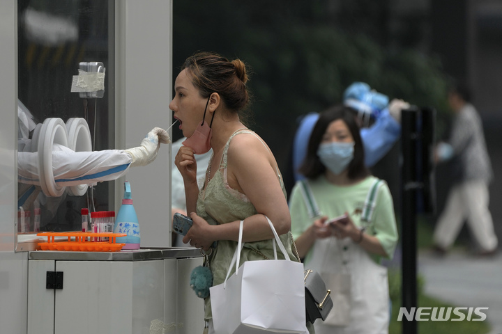 [베이징=AP/뉴시스] 12일 중국 베이징의 한 코로나19 선별검사소에서 한 여성이 검사를 받고 있다. 2022.06.12