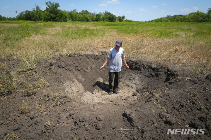 [도네츠크(우크라이나)=AP/뉴시스]우크라이나의 곡물 생산자인 농부 세르히가 지난 6월12일(현지시간) 우크라이나 동부 도네츠크 지역의 프티체 마을에서 러시아 포탄이 자신의 밭에 남긴 분화구를 보여주고 있다. 그는 아무도 러시아의 포격을 받고 있는 그 지역에 오고 싶어하지 않기 때문에 그의 곡물을 팔 수 없다고 주장했다. 우크라이나는 세계에서 가장 큰 밀과 옥수수 수출국 중 하나이지만 러시아의 침공과 항구 봉쇄로 인해 밀의 유입이 상당 부분 중단되었다. 2022.07.20.