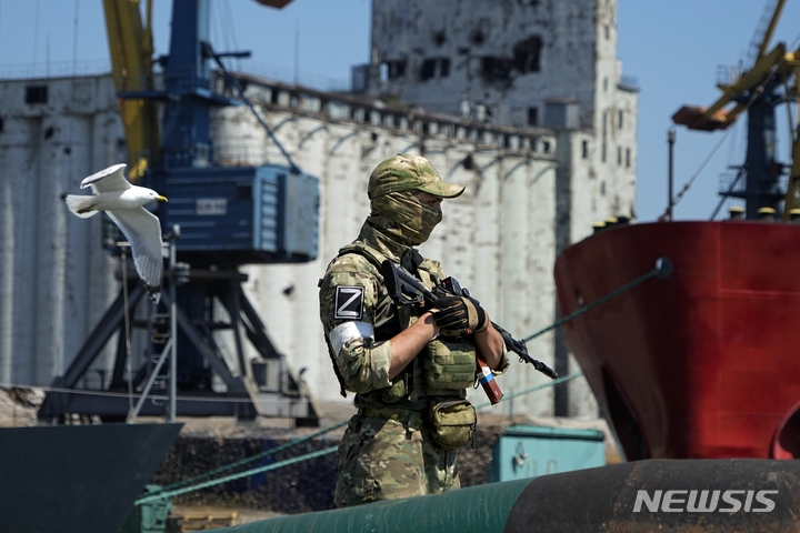[마리우폴=AP/뉴시스]지난 12일(현지시간) 러시아군이 장악한 우크라이나 동부 도네츠크주 마리우폴 항구에서 한 러시아 군인이 곡물 창고 인근 부두를 지키고 있다. 2022.06.21. 