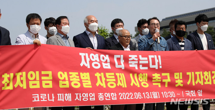 [서울=뉴시스] 고범준 기자 = 한국외식업중앙회와 한국유흥음식업중앙회 등으로 구성된 코로나피해자영업총연합 회원들이 13일 오전 서울 여의도 국회 정문 앞에서 최저임금 업종별 차등제 시행을 촉구하는 기자회견을 하고 있다. 2022.06.13. bjko@newsis.com