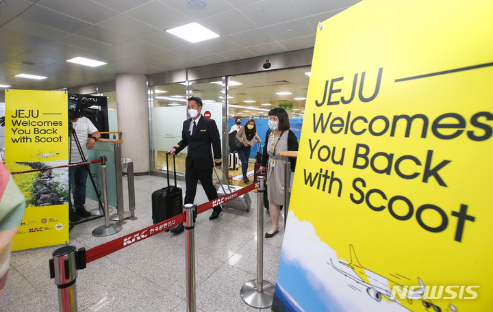 [제주=뉴시스] 우장호 기자 = 제주-싱가포르 직항 노선이 취항한 15일 오전 제주국제공항 1층 도착장에 스쿠트항공 TR812편을 타고 온 항공사 관계자들이 들어서고 있다. 제주공항의 국제 직항노선 취항은 코로나19로 인해 지난 2020년 4월 6일 인천국제공항 검역일원화에 다른 입국제한 조치 시행 후 2년 2개월만이다. 2022.06.15. woo1223@newsis.com