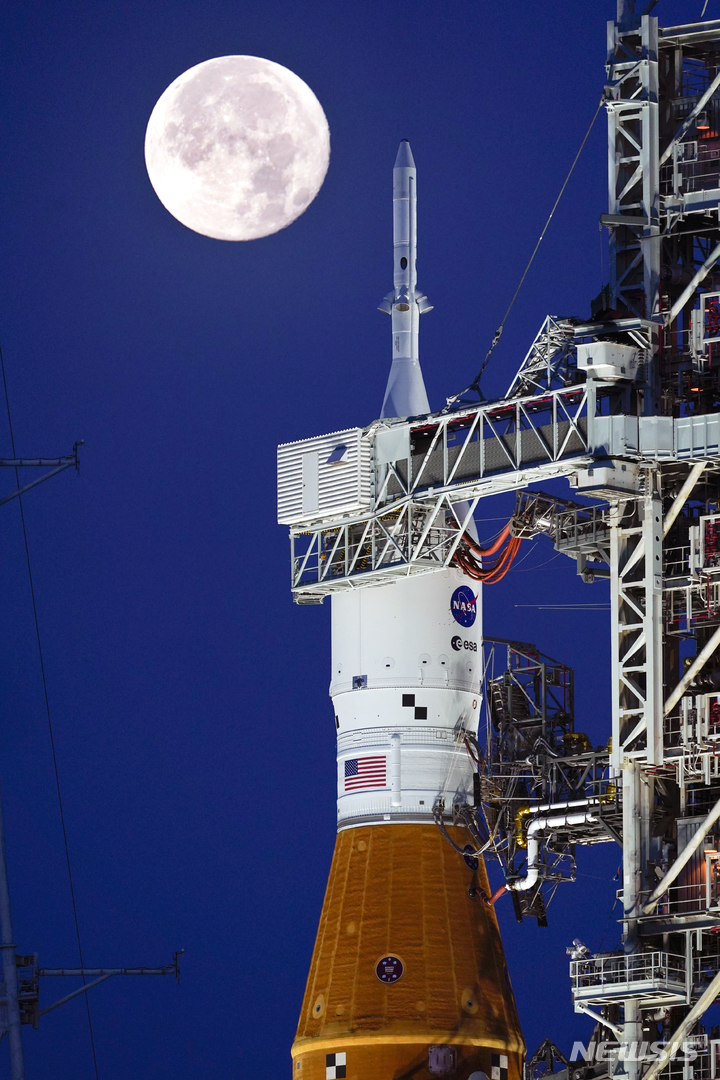[케이프커내버럴=AP/뉴시스] 15일(현지시간) 미 플로리다주 케이프커내버럴의 케네디 우주 센터 39B 발사대에 오리온 유인 우주선이 탑재된 아르테미스 로켓 앞에 슈퍼문이 떠 있다. 2022.06.15. 