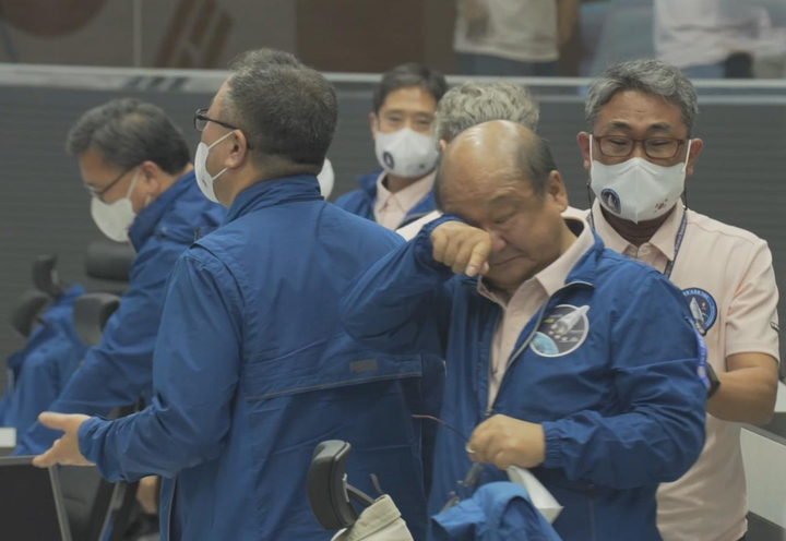 [서울=뉴시스] 순수 국내 기술로 설계·제작된 한국형 발사체 누리호(KSLV-Ⅱ) 2차 발사가 성공했다. 21일 대전시 한국항공우주연구원 위성종합관제실 관제센터에서 한 연구원(가운데)이 누리호 발사 성공에 눈물을 흘리고 있다. (사진=한국항공우주연구원 영상 캡처) 2022.06.22. photo@newsis.com *재판매 및 DB 금지