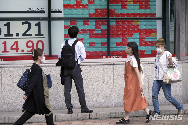 [도쿄=AP/뉴시스]지난 22일 일본 도쿄의 한 증권사 전광판을 시민이 서서 바라보고 있다. 2022.06.27.