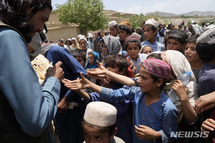 [가얀=AP/뉴시스] 26일(현지시간) 아프가니스탄 팍티카주 가얀 마을 지진 난민 수용소에서 어린이들이 빵을 받기 위해 몰려들고 있다. 2022.06.27.