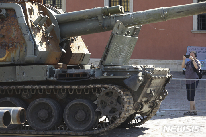 [바르샤바=AP/뉴시스] 지난달 27일(현지시간) 폴란드 바르샤바 캐슬 광장에서 사람들이 야외에 전시돼 있는 파손된 러시아 탱크와 장갑차를 사진 찍고 있다. 2022.07.05.