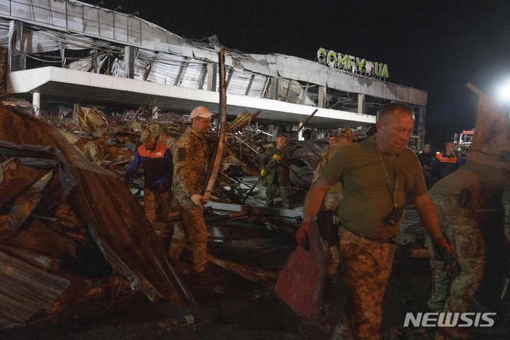 [크레멘추크=AP/뉴시스] 27일(현지시간) 우크라이나 크레멘추크에서 자원봉사자들이 러시아의 미사일 공격으로 파괴된 쇼핑몰 잔해를 치우고 있다. 우크라이나 당국은 이번 공격으로 최소 13명이 숨지고 58명이 다쳤다고 밝혔다. 2022.06.28.