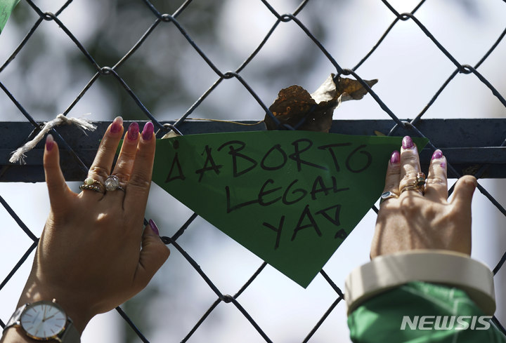 [멕시코시티=AP/뉴시스] 29일(현지시간) 멕시코 수도 멕시코시티에서 미연방대법원의 낙태 권리 폐기 판결에 항의하는 낙태 권리 지지 시위대가 미국 대사관 철망에 "낙태 합법화"라고 쓰인 팻말을 걸고 있다. 2022.06.30. 
