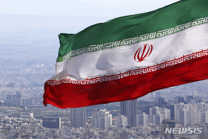 [테헤란(이란)= AP/뉴시스] 테헤란 시내에서 펄럭이는 이란 국기( AP자료사진). 이란 국영통신(IRNA)은 7월6일 이란군이 영국대사관의 부대사를 비롯한 외국 외교관들을 금지 구역에서 토양을 채취하는 등 간첩활동을 한 혐의로 체포했다고 보도했다.  