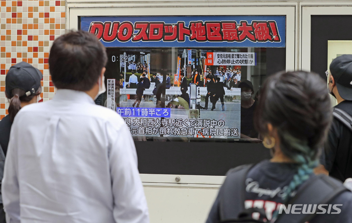 [도쿄=AP/뉴시스] 8일 일본 도쿄에서 시민들이 TV를 통해 아베 신조 전 총리의 피격 소식을 지켜보고 있다. 아베 전 총리는 나라에서 참의원 선거를 앞두고 선거 유세 중 총성과 함께 가슴 부위에 피를 흘리며 쓰러져 심정지 상태로 병원으로 옮겨졌다. 2022.07.08.