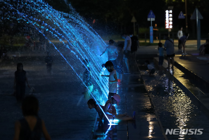 [서울=뉴시스] 서울 영등포구 여의도한강공원 물빛광장을 찾은 시민들이 더위를 식히고 있다. (사진=뉴시스DB)
