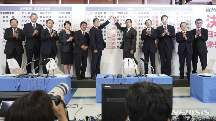 [도쿄=AP/뉴시스] 일본 여당 자민당 총재인 기시다 후미오 총리가 10일 도쿄 자민당 본부에서 당직자들과 함께 참의원 선거 공천자 게시판에 당선한 후보를 축하하는 붉은색 장미 조화를 붙이고 있다. 2022.07.11