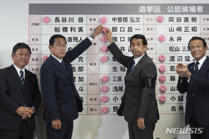 [도쿄=AP/뉴시스] 일본 여당 자민당 총재인 기시다 후미오 총리가 10일 도쿄 자민당 본부에서 참의원 선거 공천자 게시판에 당선한 후보를 축하하는 붉은색 장미 조화를 붙이고 있다. 2022.07.11