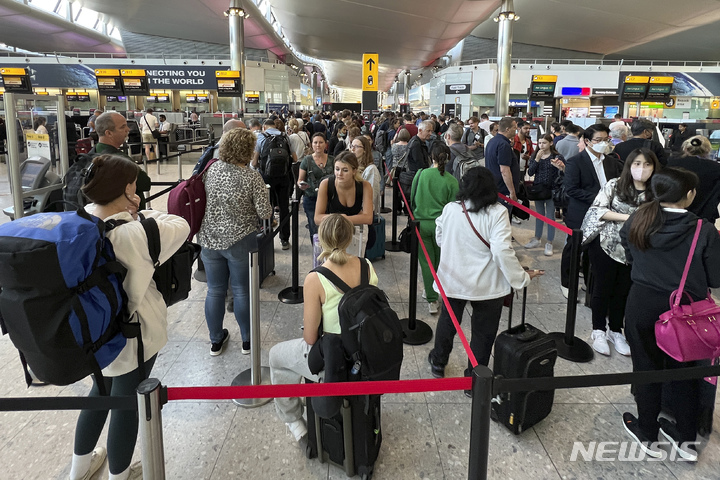 [런던=AP/뉴시스]지난 6월22일 런던 히드로 공항에 탑승 수속을 위해 여행객들이 길게 줄을 서 있다. 2022.7.13