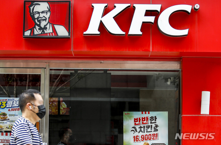 [서울=뉴시스] 정병혁 기자 = KFC 버거 제품 등의 가격을 인상한 12일 오전 서울시내에 위치한 KFC 매장 앞에서 한 시민이 이동하고 있다. KFC는 원재료 및 비용 상승 등의 이유로 이날부터 제품 가격을 200~400원 올린다고 밝혔다. 2022.07.12. jhope@newsis.com