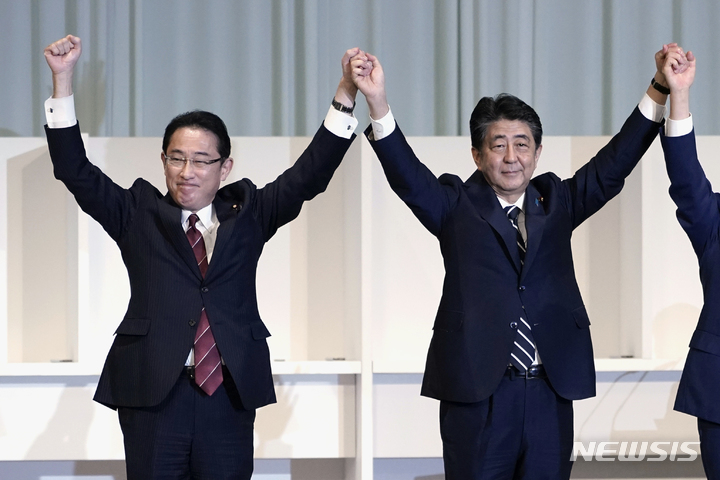 [도쿄=AP/뉴시스]지난 2020년 9월14일 일본 도쿄에서 열린 집권 자민당 총재선거에서 당시 후보였던 기시다 후미오 총리(왼쪽)와 총리 재임 중이던 아베 신조 전 총리가 손을 들어보이고 있다. 이날은 스가 요시히데 전 총리가 총재에 당선됐다. 2022.08.04.