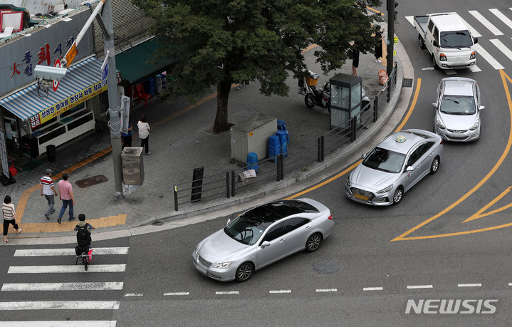 [서울=뉴시스] 백동현 기자 = 횡단보도 앞 일시정지 의무를 확대하는 등 보행자 보호의무가 강화된 도로교통법 시행 첫날인 12일 오후 서울 시내 한 횡단보도에서 우회전하는 차량이 보행자의 횡단을 기다리고 있다. 2022.07.12. livertrent@newsis.com