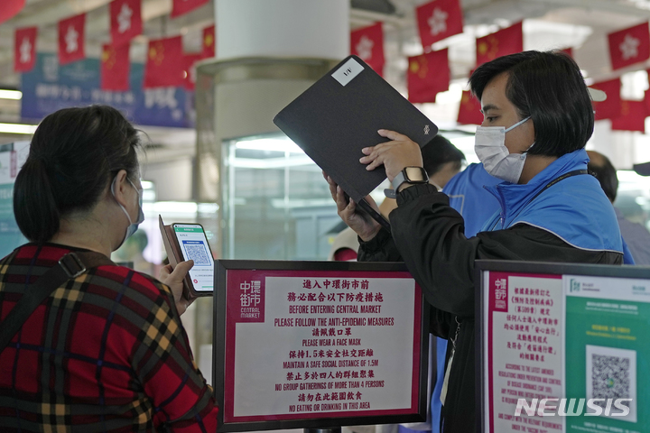 [홍콩=AP/뉴시스] 12일 홍콩의 한 쇼핑몰에서 한 고객이 정부의 코로나19 추적 앱 '리브홈세이프'(LeaveHomeSafe) 단말기에 QR 코드를 스캔하고 있다. 2022.07.12