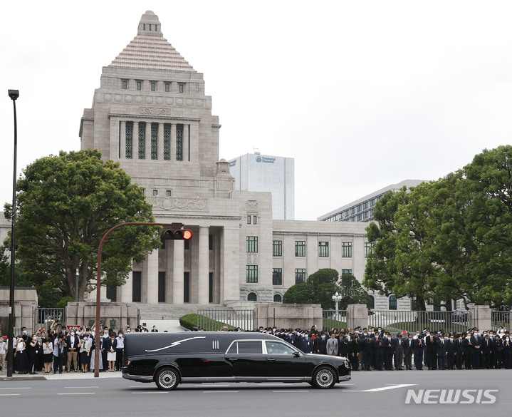 [도쿄=AP/뉴시스] 아베 신조 전 일본 총리의 시신 운구 차량이 12일 일본 도쿄의 국회의사당을 지나가고 있다. 2022.07.12.