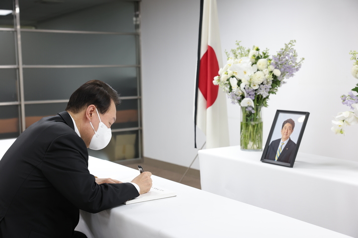 [서울=뉴시스] 윤석열 대통령이 12일 서울 종로구 일본대사관 공보문화원에 마련된 고 아베 신조 전 일본 총리 분향소를 찾아 조문한 후 방명록을 작성하고 있다. (사진=대통령실 제공) 2022.07.12. photo@newsis.com *재판매 및 DB 금지