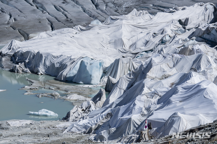 [푸르카패스=AP/뉴시스] 13일(현지시간) 스위스 푸르카패스 인근 글레처에 있는, 알프스에서 가장 오래된 론 빙하 일부가 녹는 것을 방지하기 위해 특수 흰색 천에 덮여 있다. 2022.07.14. 
