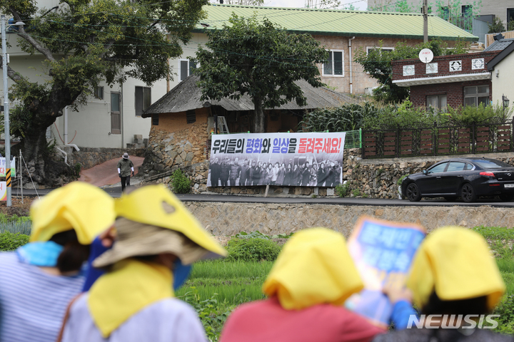 [양산=뉴시스] 차용현 기자 = 17일 오후 경남 양산시 하북면 평산마을 문재인 전 대통령 사저 앞에서 진보 단체 집회자들이 문 전 대통령 내외를 지지하는 문구가 적힌 피켓을 들어보이고 있다. 2022.07.17. con@newsis.com