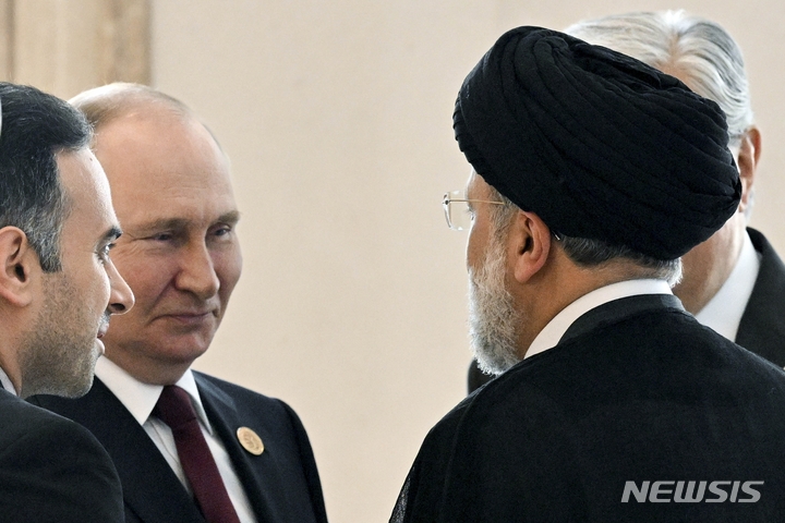 [AP/뉴시스] 지난 6월29일 사진으로 러시아의 블라디미르 푸틴 대통령이 투르메니스탄에서 열린 카스피해 연안국가 정상회담에 참석해 이란의 에브라힘 라이시 대통령과 이야기하고 있다