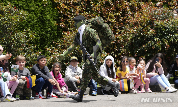 [보고타=AP/뉴시스] 20일(현지시간) 콜롬비아 수도 보고타에서 제212주년 콜롬비아 독립 기념일을 맞아 열린 퍼레이드에 참석한 한 군인이 구경나온 어린이들에게 인사를 건네고 있다. 2022.07.21.