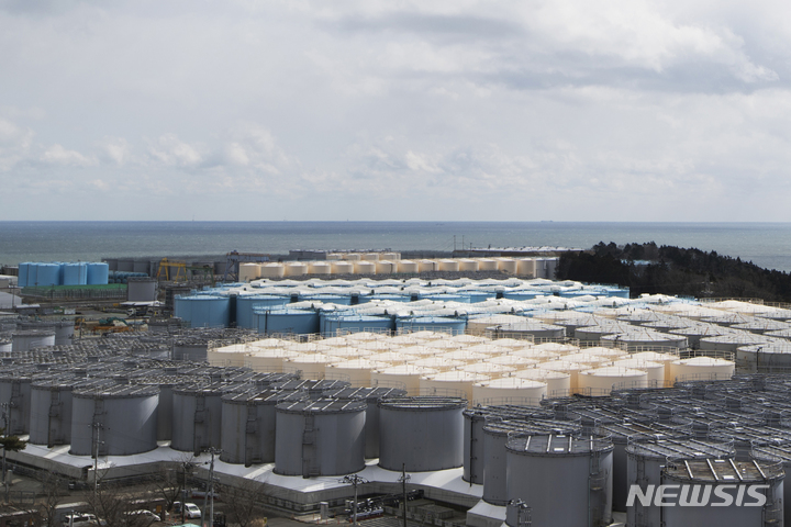[후쿠시마=AP/뉴시스]2021년 2월 일본 북동부 후쿠시마현 오쿠마초에 있는 후쿠시마 제1원자력발전소에서 연료를 식히는 데 사용된 후 여전히 방사능을 띤 물을 저장하고 있는 탱크(회색, 베이지색 및 파란색)의 모습. 2023.03.11.