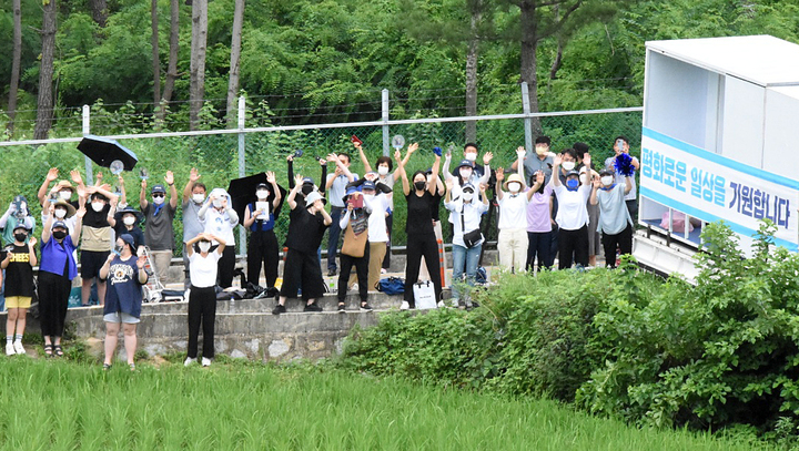 [서울=뉴시스] 백동현 기자 = 23일 오후 경남 양산시 평산마을 사저 앞에서 보수단체 욕설 집회에 맞서 평화적 침묵시위를 이어가는 지지자들이 문재인 전 대통령을 향해 손을 흔들고 있다. (사진=전 청와대 행정관 SNS 캡처) 2022.07.23. photo@newsis.com *재판매 및 DB 금지