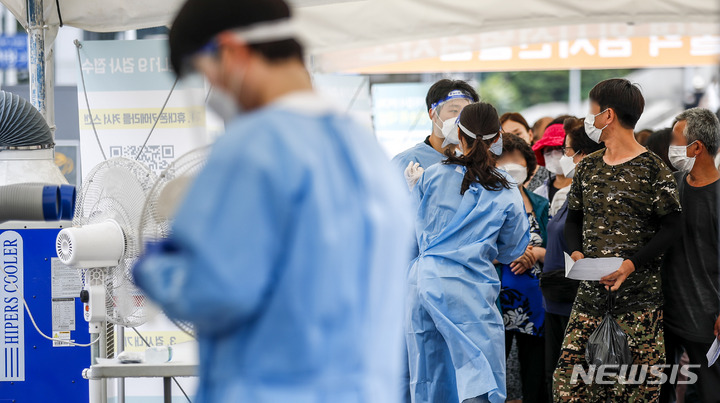 [서울=뉴시스] 정병혁 기자 = 0시 기준 국내 코로나19 신규 확진자가 10만285명으로 집계된 27일 오전 서울 중구 서울역광장에 설치된 임시선별검사소를 찾은 시민들이 검사를 받기 위해 줄 서 있다. 2022.07.27. jhope@newsis.com