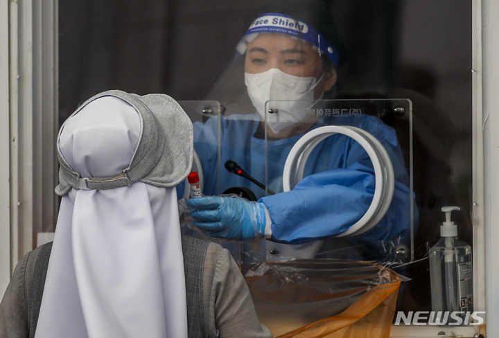 [서울=뉴시스] 정병혁 기자 = 0시 기준 국내 코로나19 신규 확진자가 10만285명으로 집계된 27일 오전 서울 중구 서울역광장에 설치된 임시선별검사소를 찾은 한 수녀가 코로나19 검사를 받고 있다. 2022.07.27. jhope@newsis.com