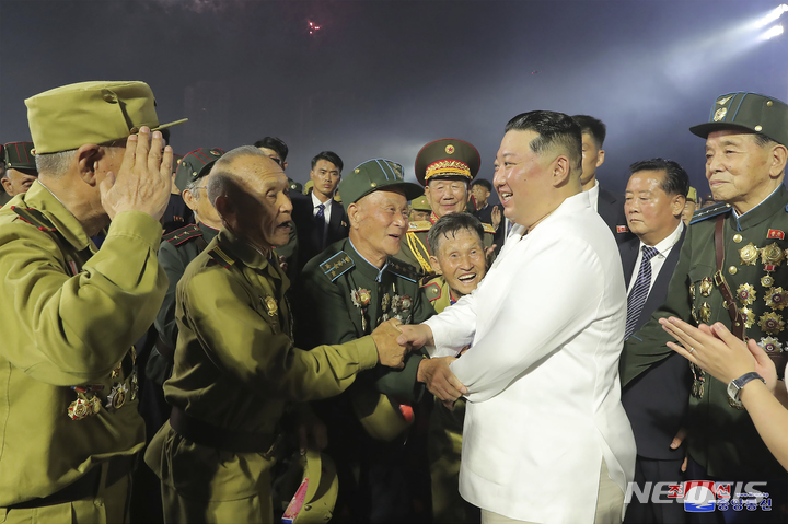 [평양=AP/뉴시스] 북한 조선중앙통신이 제공한 사진에 김정은(가운데) 국무위원장이 27일 평양에서 열린 6·25전쟁 정전협정 체결 69주년 기념식에 참석해 참전 군인들과 악수하고 있다. 북한은 6·25 한국전쟁 정전 체결을 미군에 승리했다고 주장하며 '조국 해방전쟁 승리의 날'(전승절)로 기념한다. 2022.07.28.