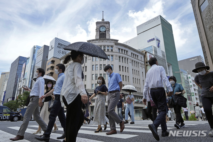 [도쿄=AP/뉴시스]지난달 28일 일본 도쿄 긴자 거리에서 마스크를 착용한 시민들이 횡단보도를 건너고 있다. 2022.08.12.