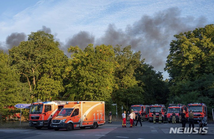 [베를린(독일)=AP/뉴시스]4일(현지시간) 독일 수도 베를린 남서쪽에 위치한 도심 숲 '그루네발트(Grunewald)' 안에 있던 경찰 탄약고가 폭발해 화재가 발생했다. 화재 진압을 위해 출동한 소방관들의 모습이다. 2022.08.04.