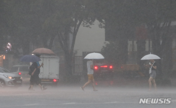 [서울=뉴시스] 권창회 기자 = 비가 내리고 있는 지난 8일 오후 서울 강동구 둔촌역 인근에서 시민들이 우산을 쓰고 이동하고 있다. 2022.08.08. kch0523@newsis.com