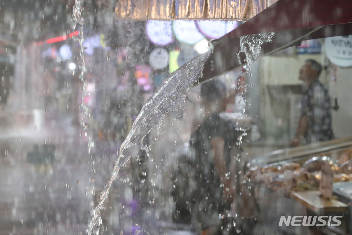 [서울=뉴시스] 권창회 기자 = 비가 내리고 있는 8일 오후 서울 강동구 둔촌역 전통시장에서 빗물이 쏟아지고 있다. 2022.08.08. kch0523@newsis.com
