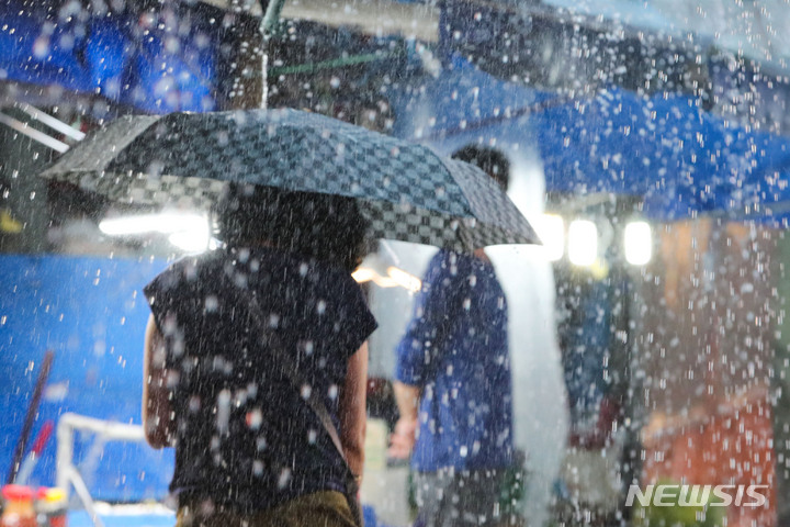 [서울=뉴시스] 권창회 기자 = 지난 8일 서울 강동구 둔촌역 전통시장에서 시민들이 우산을 쓰고 이동하고 있다. 2022.08.08. kch0523@newsis.com