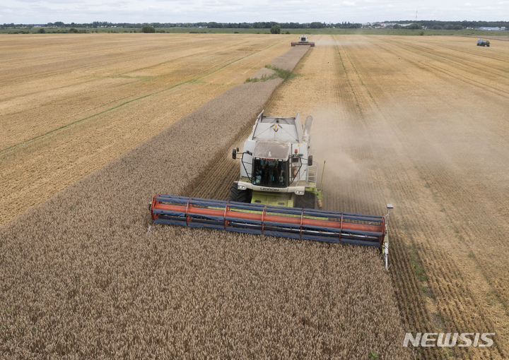 [즈흐리우카=AP/뉴시스] 9일(현지시간) 우크라이나 즈흐리우카의 밀밭에서 농민들이 밀을 수확하고 있다. 한 달에 450만 톤의 농산물을 수출해 '세계의 빵 바구니'로 불리던 우크라이나는 전쟁이 터지면서 수출길이 막혔다. 지난달 튀르키예와 유엔의 중재로 수출길이 재개되면서 우크라이나 곡물 선박들이 잇따라 출항하고 외국 국적 선박도 입항하면서 곡물 공급에 숨통이 트일 것으로 기대되고 있다. 2022.08.10.