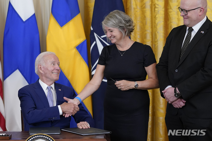 [워싱턴=AP/뉴시스] 조 바이든 미국 대통령이 9일(현지시간) 백악관 이스트룸에서 핀란드·스웨덴의 북대서양조약기구(NATO·나토) 가입 비준안에 서명한 뒤 카린 올롭스도터 주미스웨덴 대사와 악수하고 있다. 오른쪽은 미코 하우탈라 주미핀란드 대사. 2022.08.10.