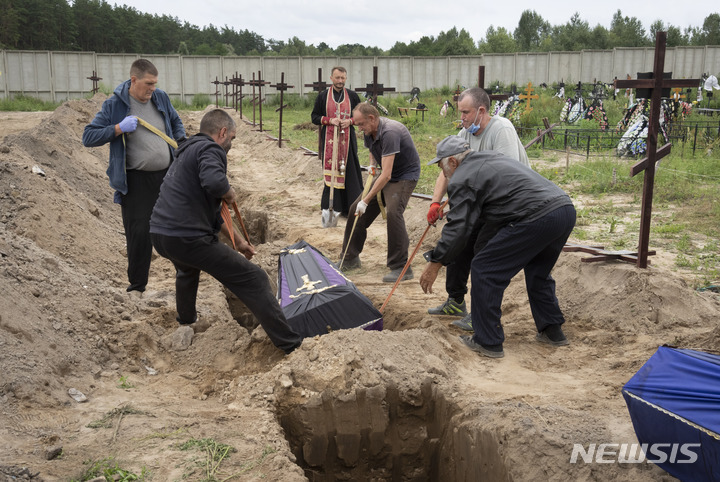 [부차=AP/뉴시스] 11일(현지시간) 우크라이나 키이우 외곽 부차에서 러시아군에 의해 살해된 신원 미상의 민간인 시신이 무덤에 묻히고 있다. 2022.08.12. 