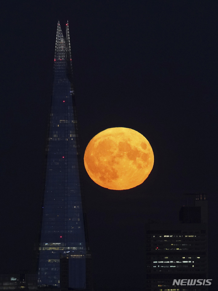 [런던=AP/뉴시스] 11일(현지시간) 영국 런던의 샤드 타워 뒤로 슈퍼문이 떠오르고 있다. 2022.08.12.