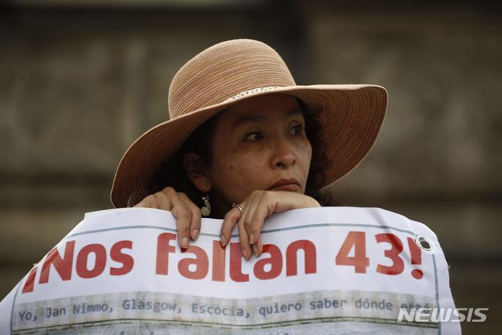 [멕시코시티=AP/뉴시스]한 여성이 지난 2015년 11월26일 멕시코시티에서 실종된 43명의 학생들을 지칭하는 '우리는 43명을 놓치고 있다'라고 스페인어로 쓰인 현수막을 들고 행진하고 있다. 지난 2014년 멕시코 남부에서 발생한 학생 43명의 실종 사건을 규명하기 위해 설립된 진실위원회가 18일(현지시간) 군인 1명이 학생 단체에 침투했고 군이 무슨 일이 일어나는지 알고 있었기 때문에 적어도 납치를 막지 못한 데 대해서는 책임이 있다고 말했다. 2022.8.19