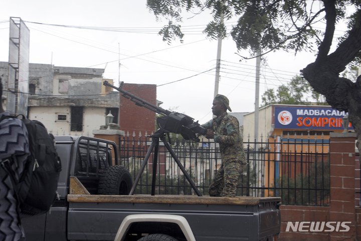 [모가디슈( 소말리아)= AP/뉴시스] 소말리아 모가디슈의 하이야트 호텔 테러 현장 앞에서 8월 20일 정부군 무장 순찰대가 인근을 경계하고 있다. 19일 발생한 호텔 테러로 어린이를 포함한 15명이 숨졌고 보안군이 진입해서 20일에는 호텔을 장악했다고 목격자들이 전했다.