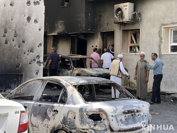[트리폴리=신화/뉴시스]2022년 8월 28일(현지시간) 리비아 수도 트리폴리에서 앞서 임시정부 간 유혈 사태로 파손된 건물 근처에 주민들이 모여 있다. 현지 당국은 8월 26일 발생한 2개의 임시정부 간 유혈 충돌로 지금까지 32명이 숨지고 159명이 다쳤다고 밝혔다. 2023.05.30.